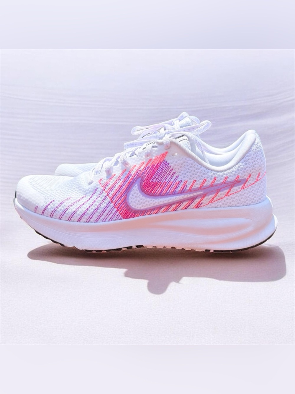 Nike Women's Run Defy running shoes, featuring a white mesh upper